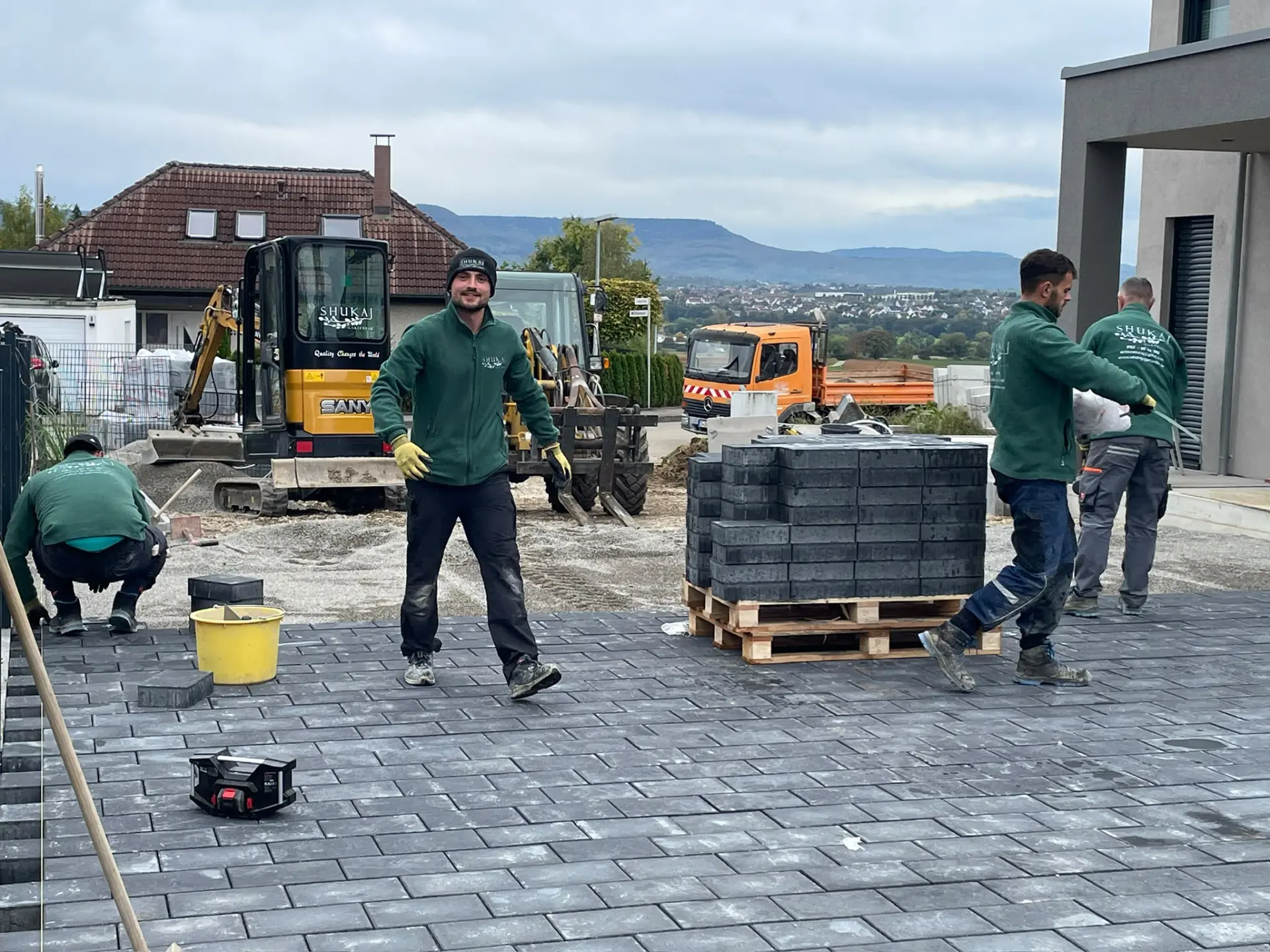Team von Shukaj Gartenbau beim Verlegen der Pflastersteine vor der Villa