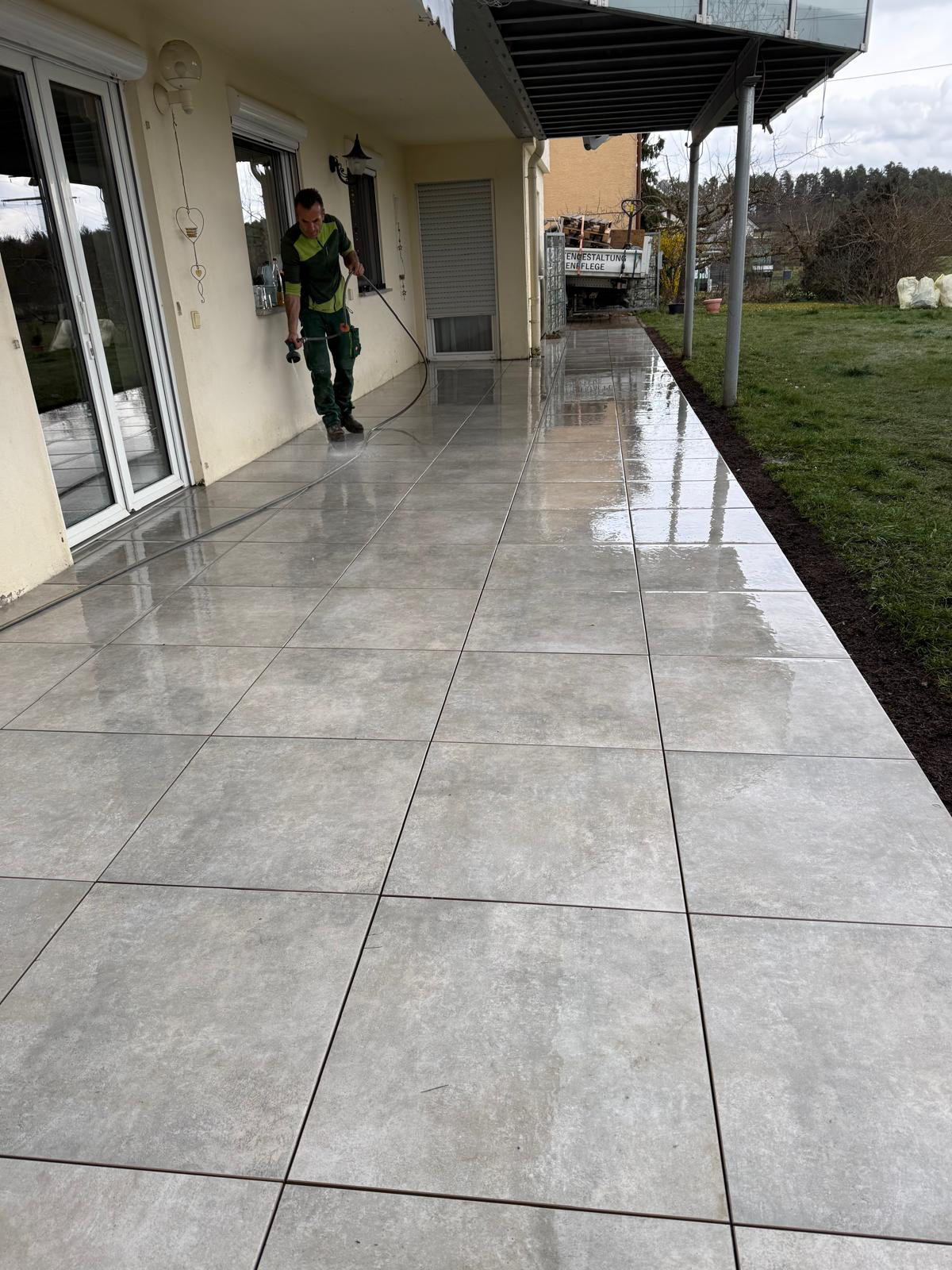 Fertige Terrasse mit großformatigen hellen Feinsteinzeugplatten nach der Reinigung