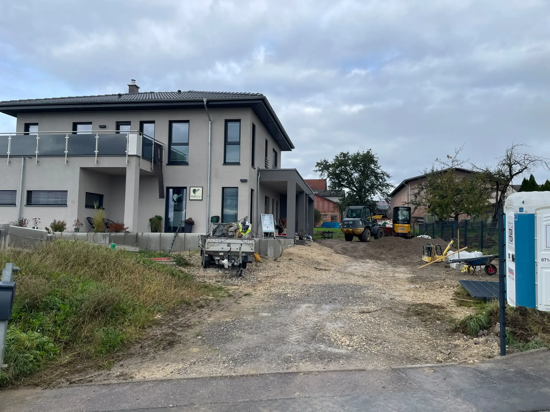 Hoffläche vor den Pflasterarbeiten: unbefestigter Schotterboden vor dem Neubau